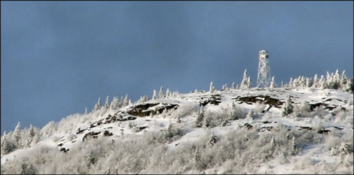 Friends of the St. Regis Fire Tower: Telephoto view of St. Regis summit and Tower from St. Regis Pond. Photo courtesy of Gordon Keyes.