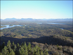 St. Regis Tower Cab View on 21 October 2001, looking south. In the center of this photo is Lake Clear Lake with Upper St. Regis Lake to the left. On the horizon are the High Peaks with Whiteface Mountain visible to the left. Photo courtesty of Friends of the St. Regis Fire Tower.